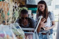 Man in Black Sunglasses Holding Smartphone Beside Woman in Blue Denim Jacket