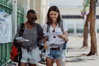 两名女性旅行者一边用地图探索城市，一边享受旅程