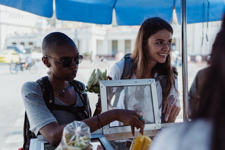 Smiling People Buying Food From Vendor