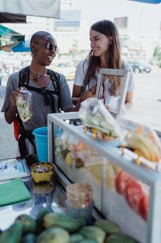 两名女子在户外市场愉快地探索街头美食