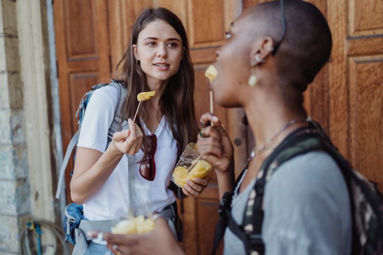 Two Women Eating On The Street