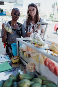 Two women standing at a street food stall, smiling and enjoying the day.