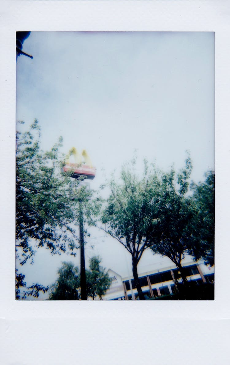 Blurred Shot Of Mcdonalds Sign Near Trees