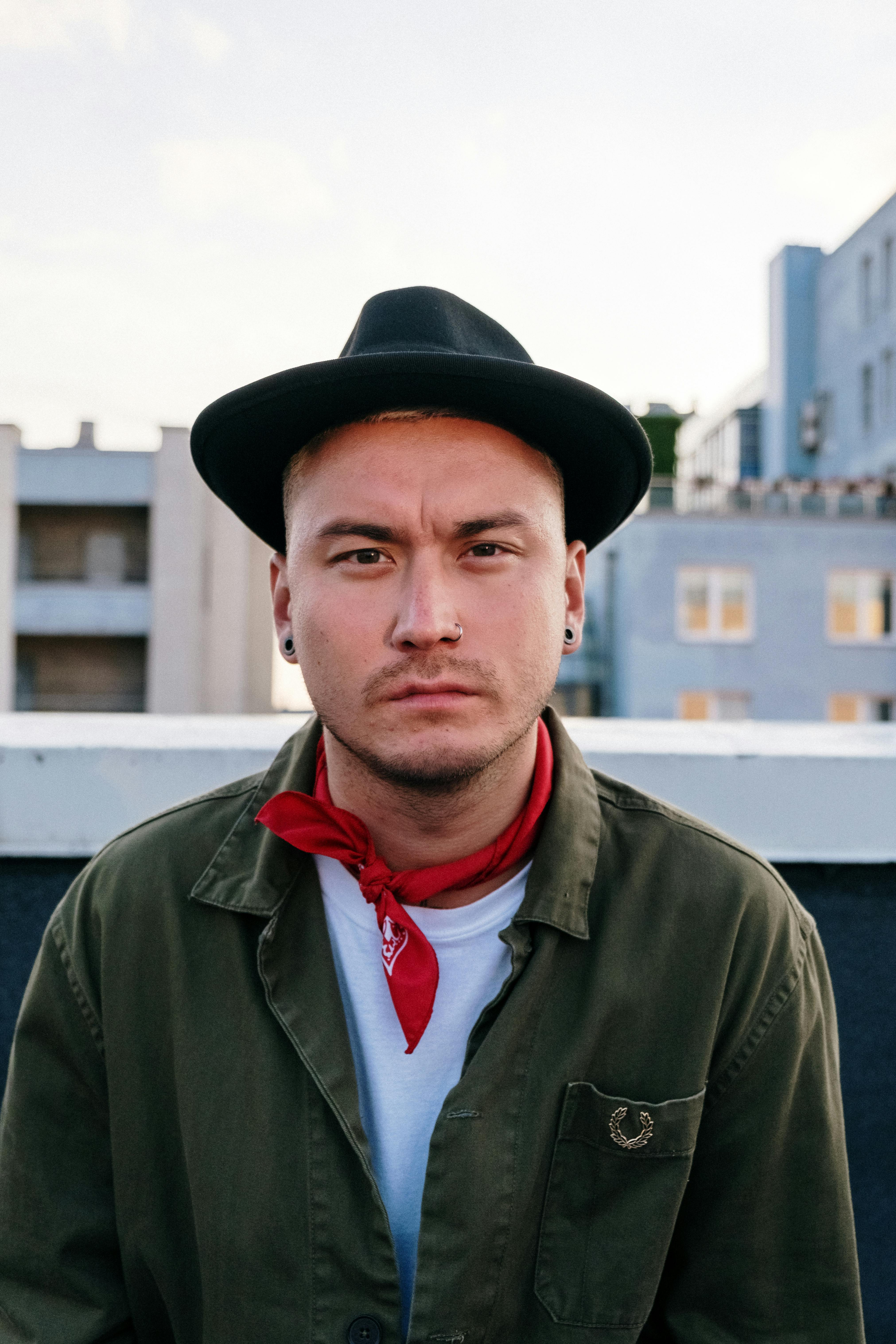 man in green button up shirt and black fedora hat