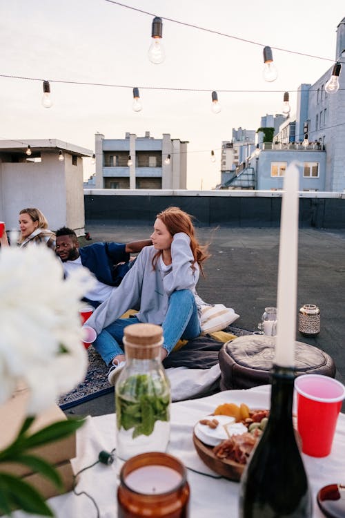 Woman in Blue Long Sleeve Shirt Sitting on Gray Concrete Bench