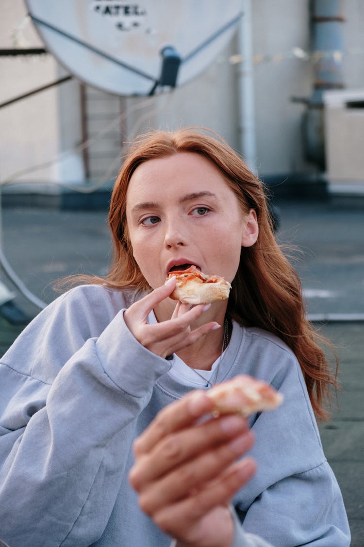 Woman In White Long Sleeve Shirt Eating Bread