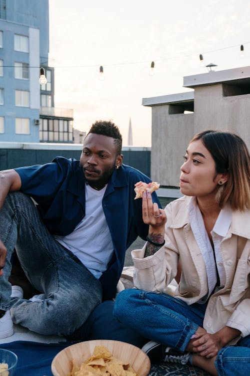 Man in Blue Sweater Sitting Beside Woman in Gray Coat