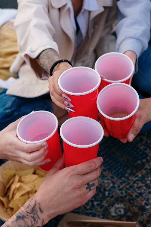Person Holding Red and White Cups