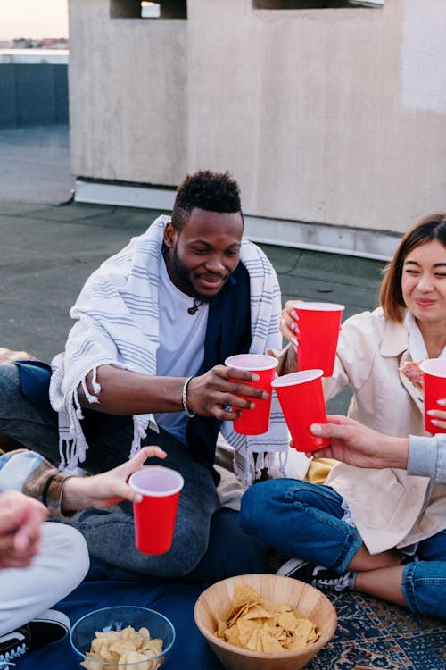 Man in White Dress Shirt Holding Red and White Cup