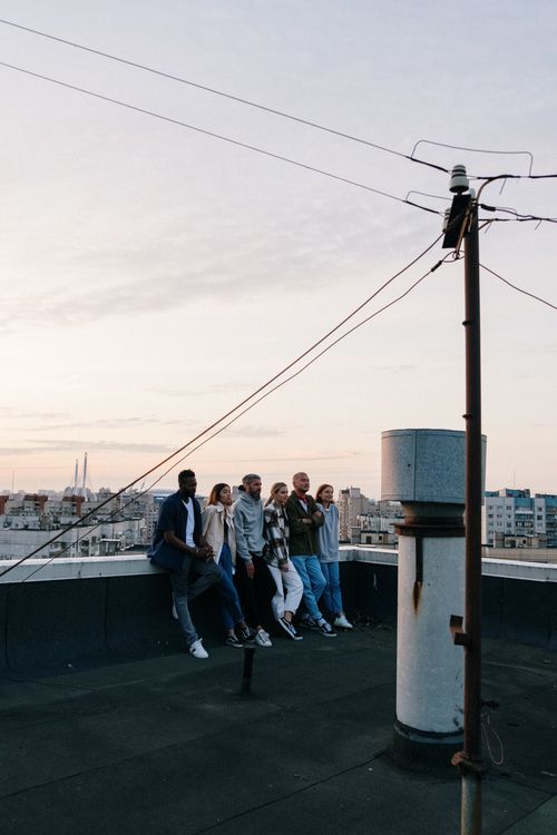 Free A group of friends enjoying a relaxed evening on a city rooftop, embracing urban lifestyle. Stock Photo