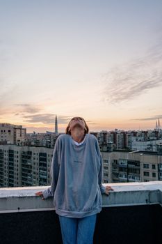 一名女子在城市屋顶上享受日落，沉浸在宁静的夜色中