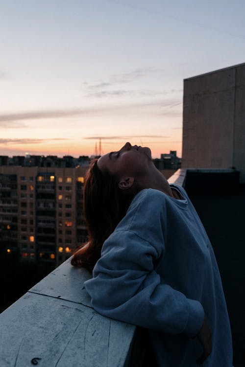 Free Woman in Blue Hoodie Standing Near Building Stock Photo