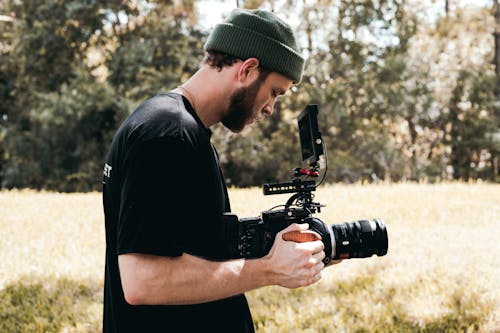 Man in Black Crew Neck T-shirt Holding Black Dslr Camera