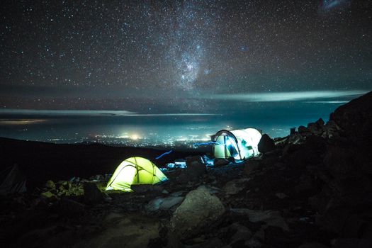 在令人惊叹的星空下，乞力马扎罗山上明亮的帐篷捕捉到了夜间冒险的精髓