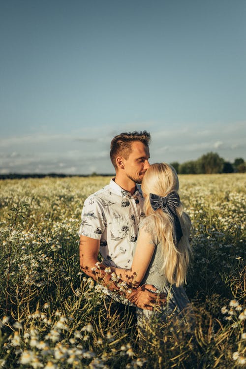 Couple Hugging Each Other while Standing on a Flower Field 