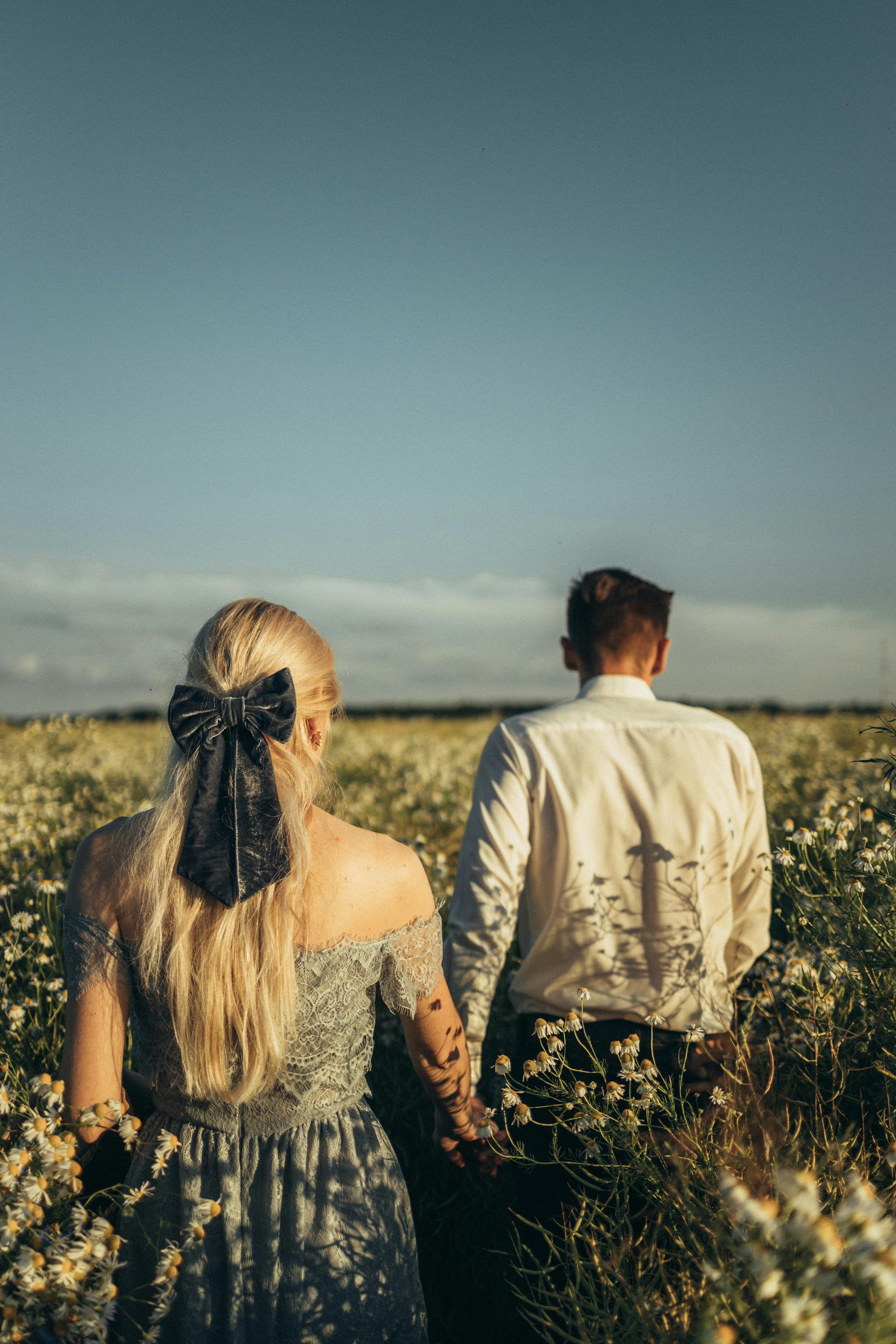 白天，一对浪漫的情侣手牵手走过洋地黄田