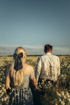 白天，一对浪漫的情侣手牵手走过洋地黄田