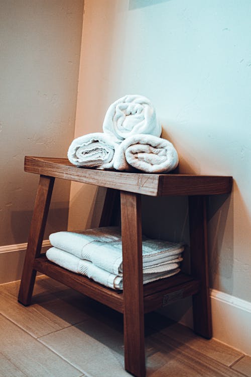 White Bath Towels on a Wooden Table