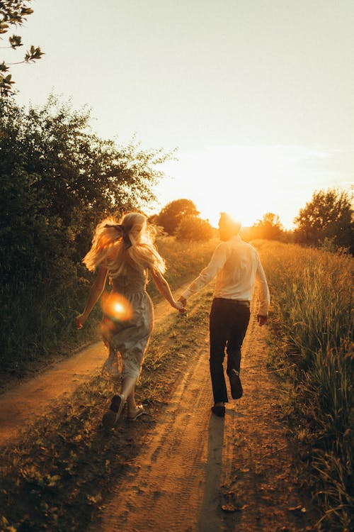 Free Couple Running while Holding Hands Stock Photo