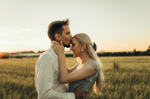 Free Man Kissing His Partner on the Forehead Stock Photo