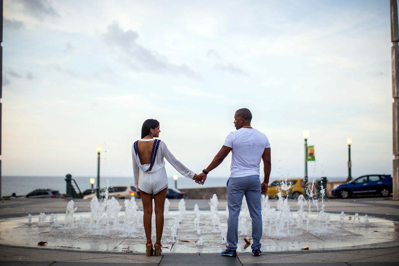 Black couple holding hands beside a waterfront, representing companionship, discernment and mutual commitment
