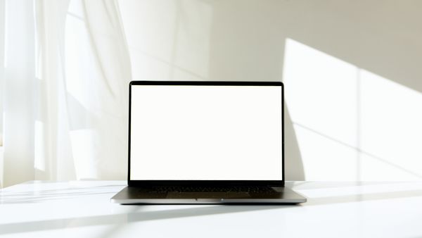 A laptop with a blank screen on a sunlit table — photo by Artem Podrez on Pexels