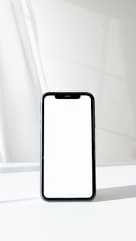 Close-up of a smartphone with a blank white screen, ideal for digital and tech concepts.