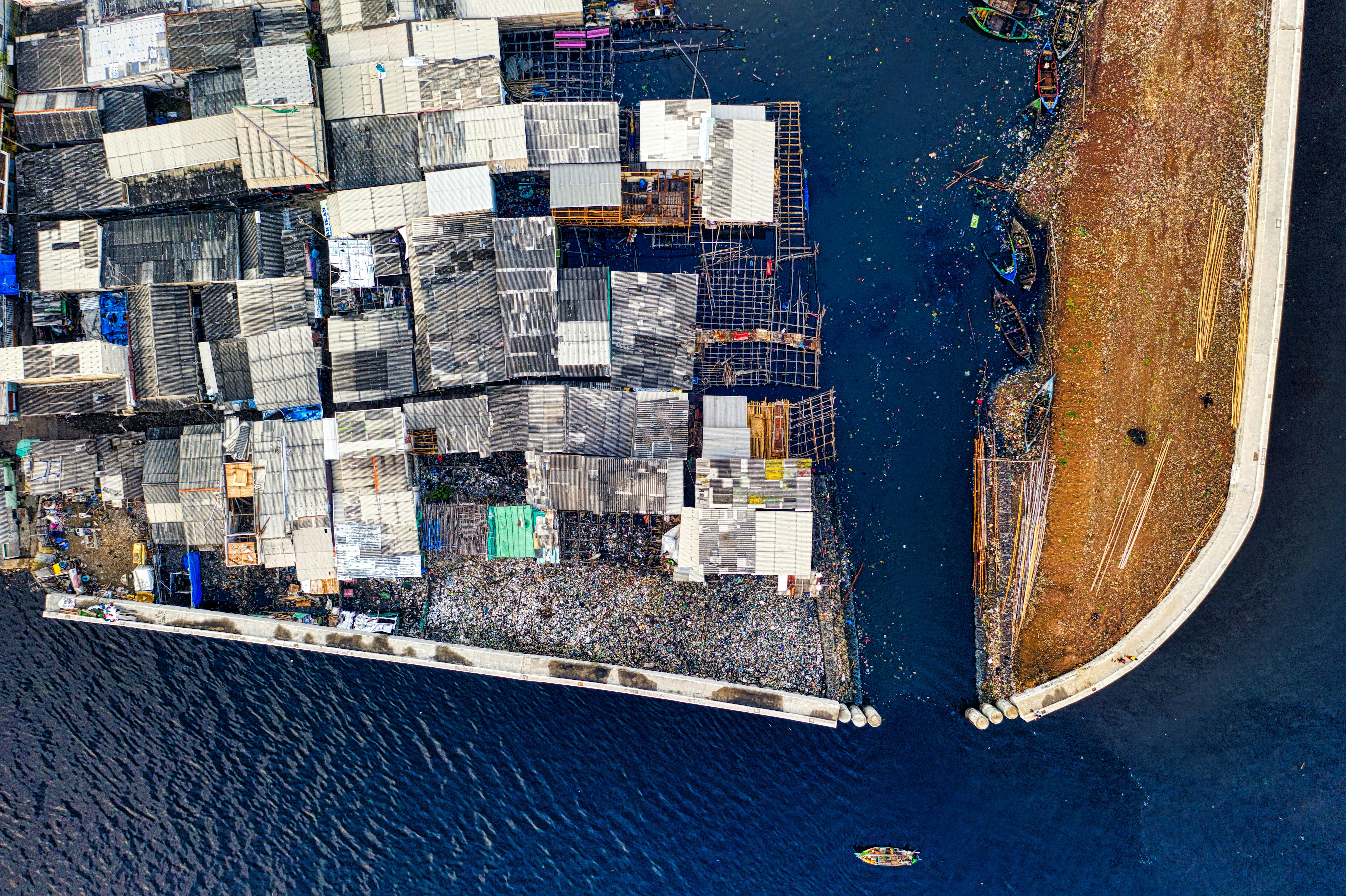 aerial view of white and black building beside body of water