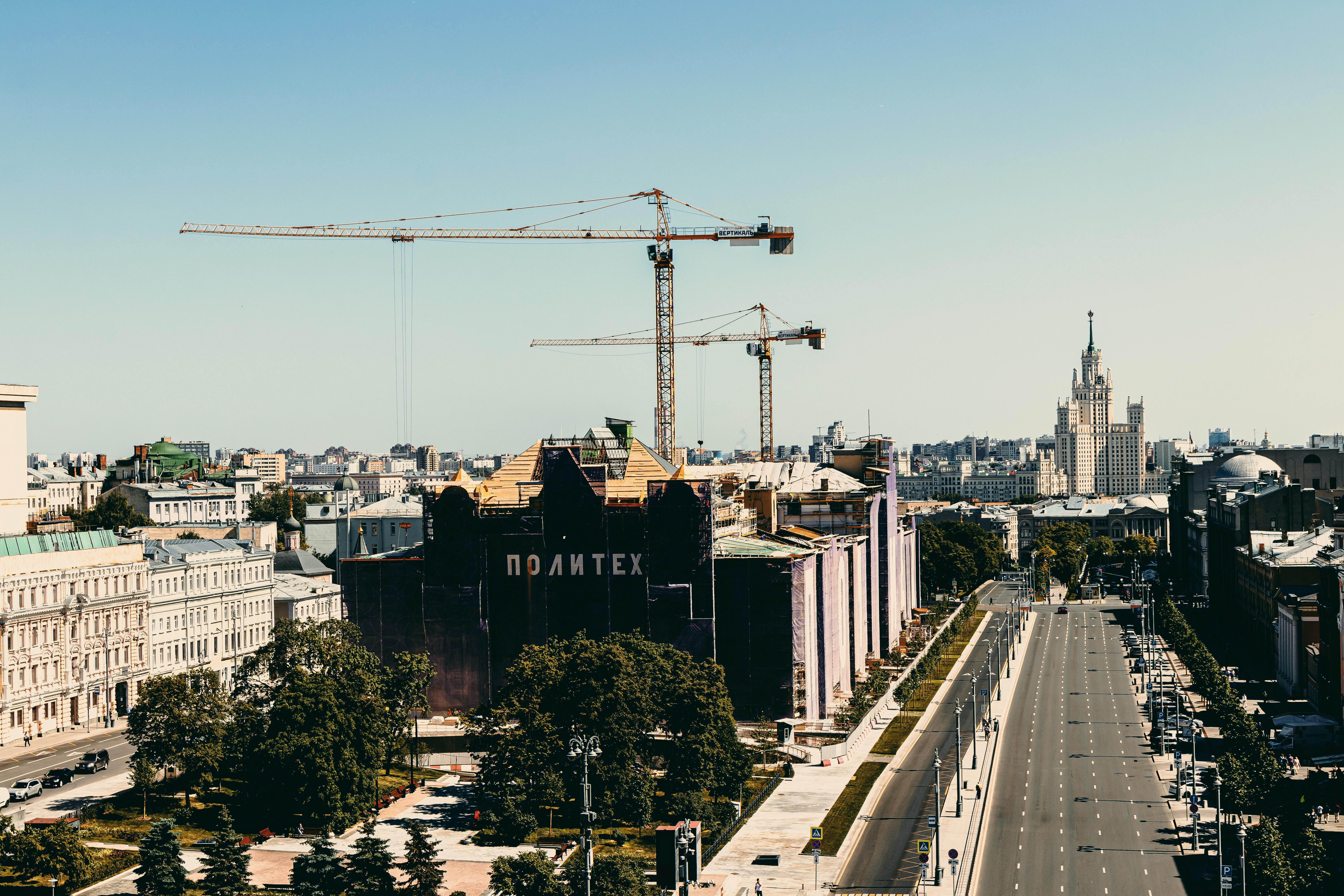 Brown and Black Concrete Building Near Gray Concrete Bridge Under Blue Sky