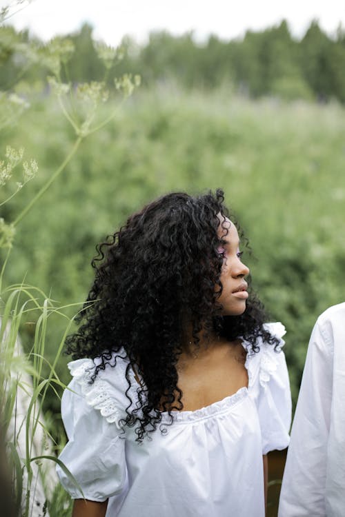 Woman in White Shirt Standing on Green Grass Field