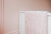 托儿所的白色婴儿床上，铺着一条粉色星星图案的毯子