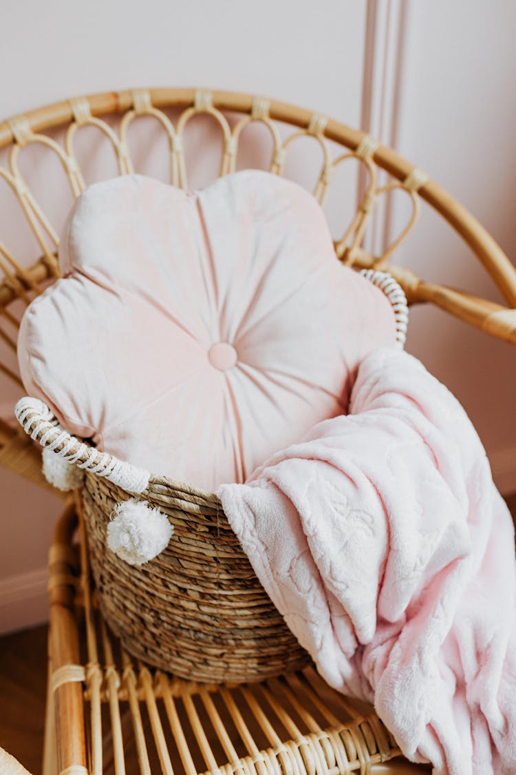 A Pillow And A Blanket In A Woven Basket