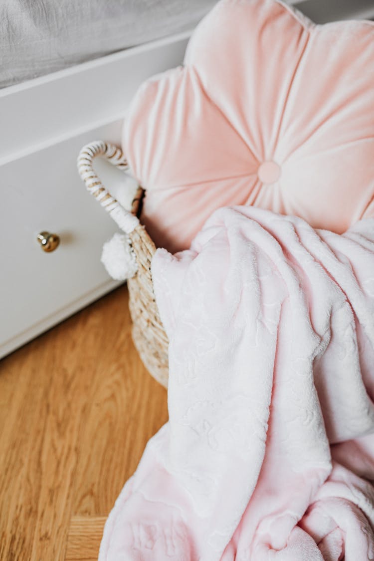 Close-up Of A Pillow And A Blanket In A Woven Basket