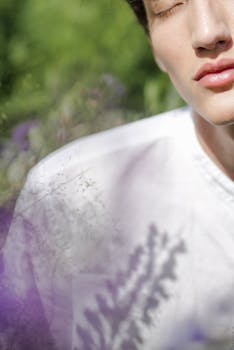 一位年轻人的特写肖像，被柔和的紫罗兰色花朵环绕着