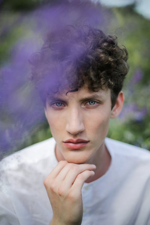 Man in White Crew Neck Shirt With Blue and Green Powder on His Face