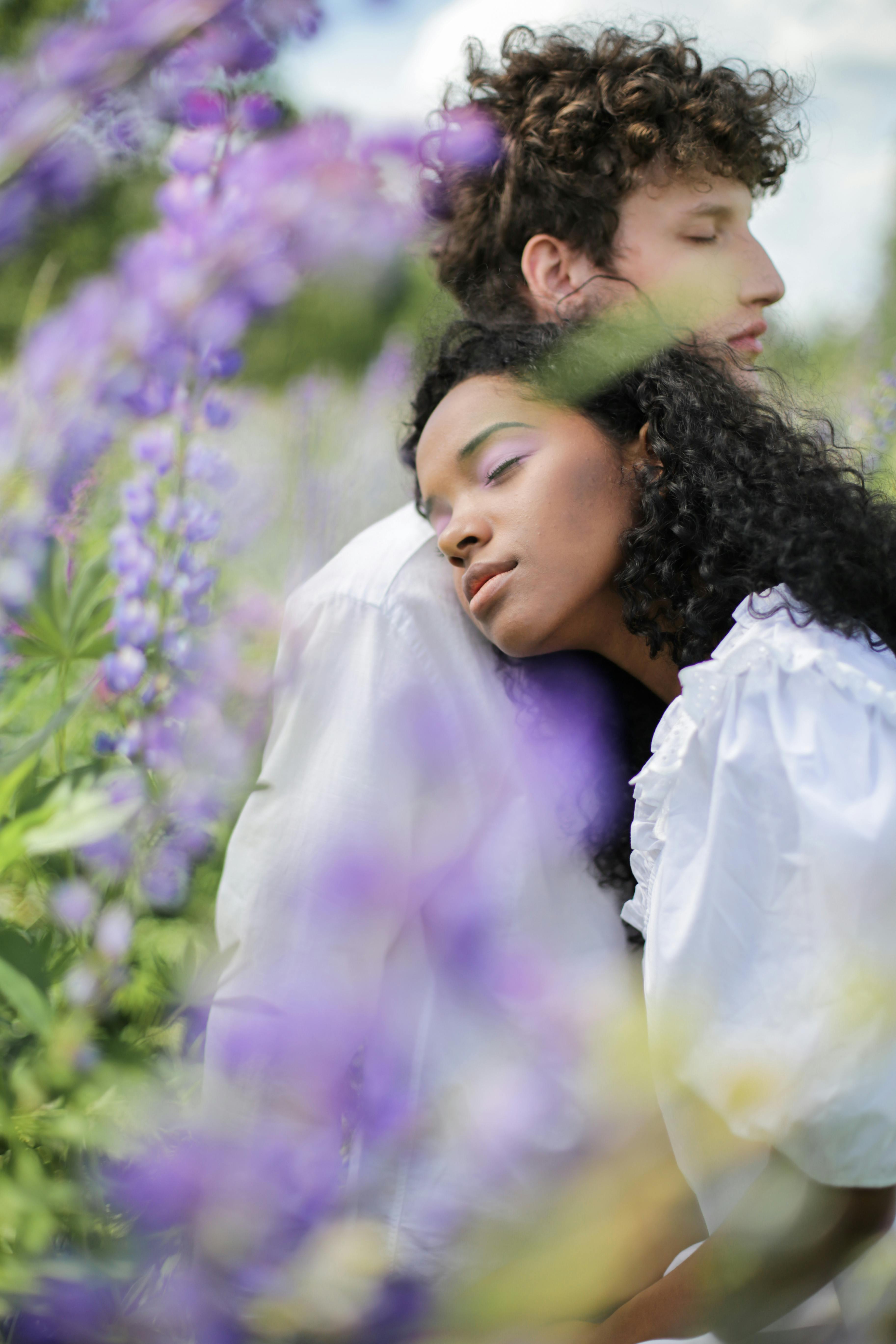 夏日，一对情侣在盛开的紫色扁豆花丛中相拥，散发着爱与宁静