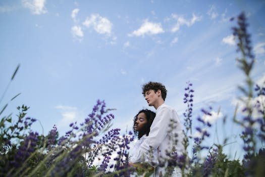 一对情侣在晴朗的夏日天空下，于郁郁葱葱的雨夹雪中浪漫相拥