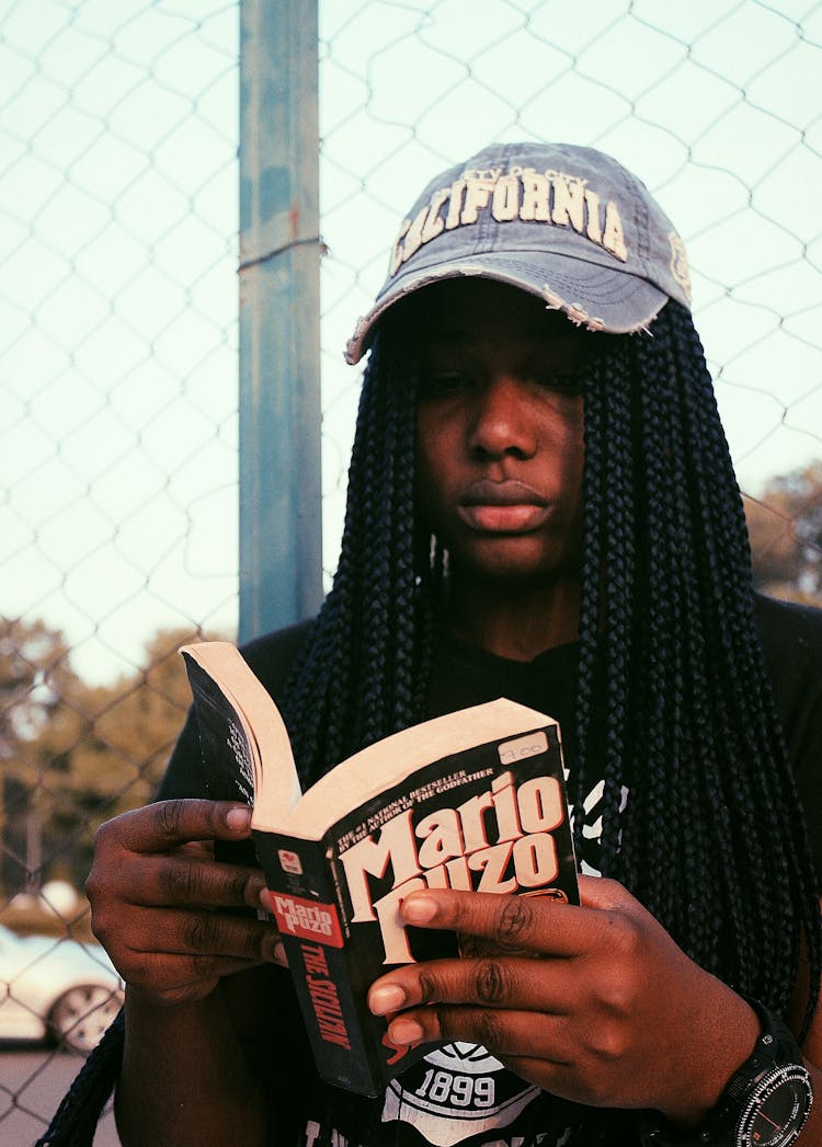 Black Woman Reading Book On Sports Ground