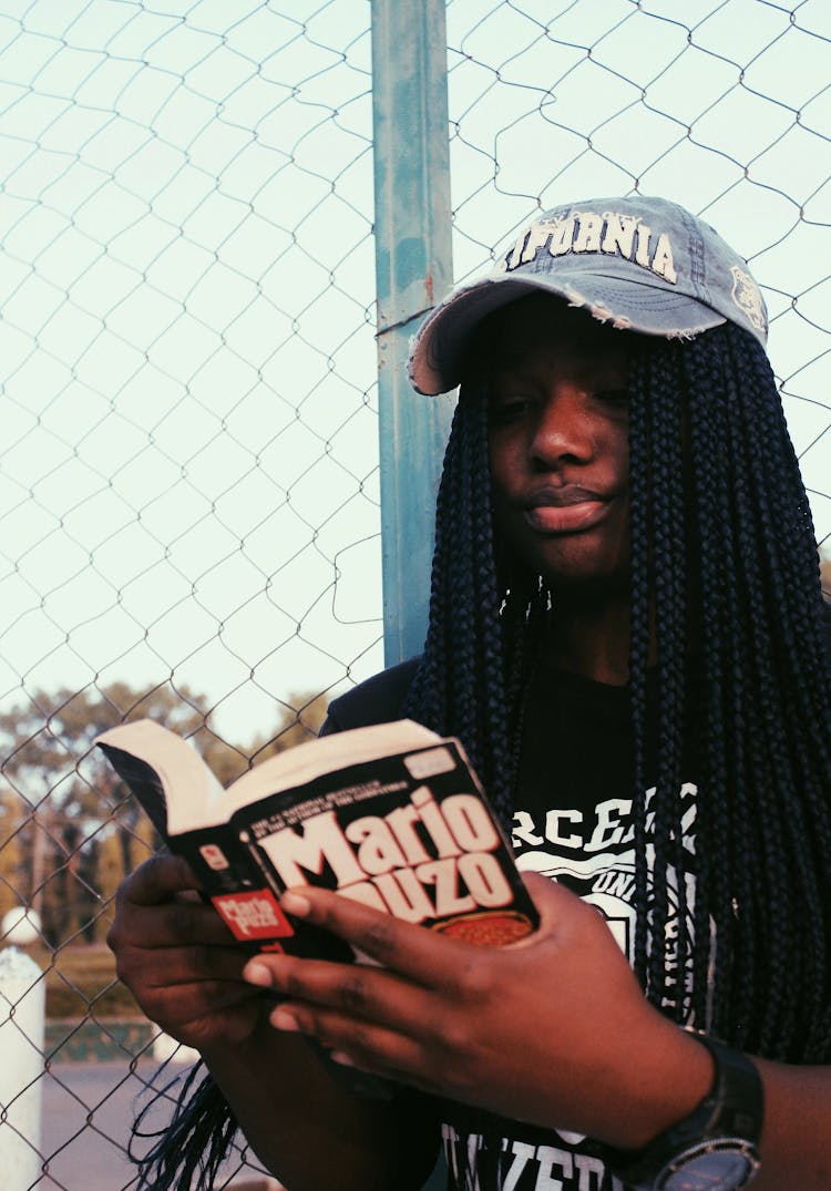 Black Woman Reading Book On Street