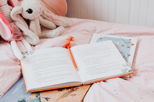 一张粉色的床上摊开着一本书，旁边放着铅笔和毛绒兔子玩具，营造出舒适的阅读氛围