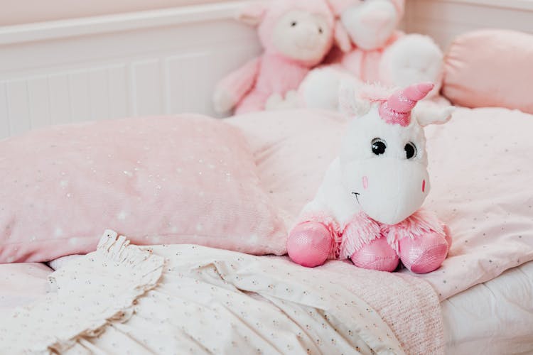 White And Pink Unicorn Plush Toy On Bed
