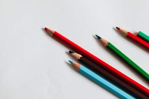 Free A vibrant assortment of colored pencils arranged on a white surface, perfect for creative projects. Stock Photo