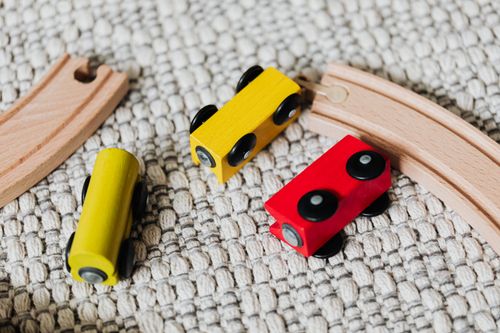 Free Close-up of a colorful wooden train set on a textured carpet, showcasing vibrant playtime. Stock Photo