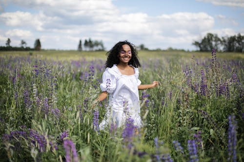 Woman in White Dress Standing on Purple Flower Field