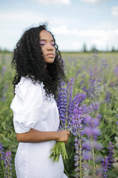 Woman in White Shirt Standing on Green Grass Field