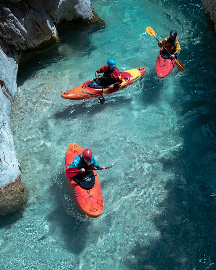 People Kayaking On Clear Water River