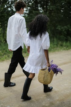 一对夫妇手牵着手，漫步在乡村小路上，拥抱自然与浪漫