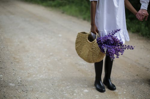 Woman in White Dress Holding Brown Woven Basket