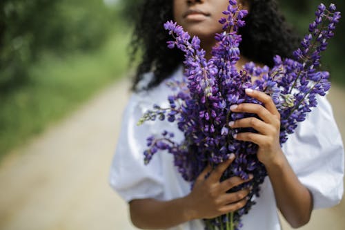 Person Holding Purple Flowers