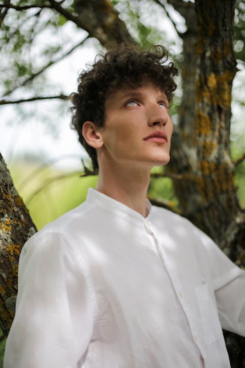 Man in White Dress Shirt Standing Near Brown Tree